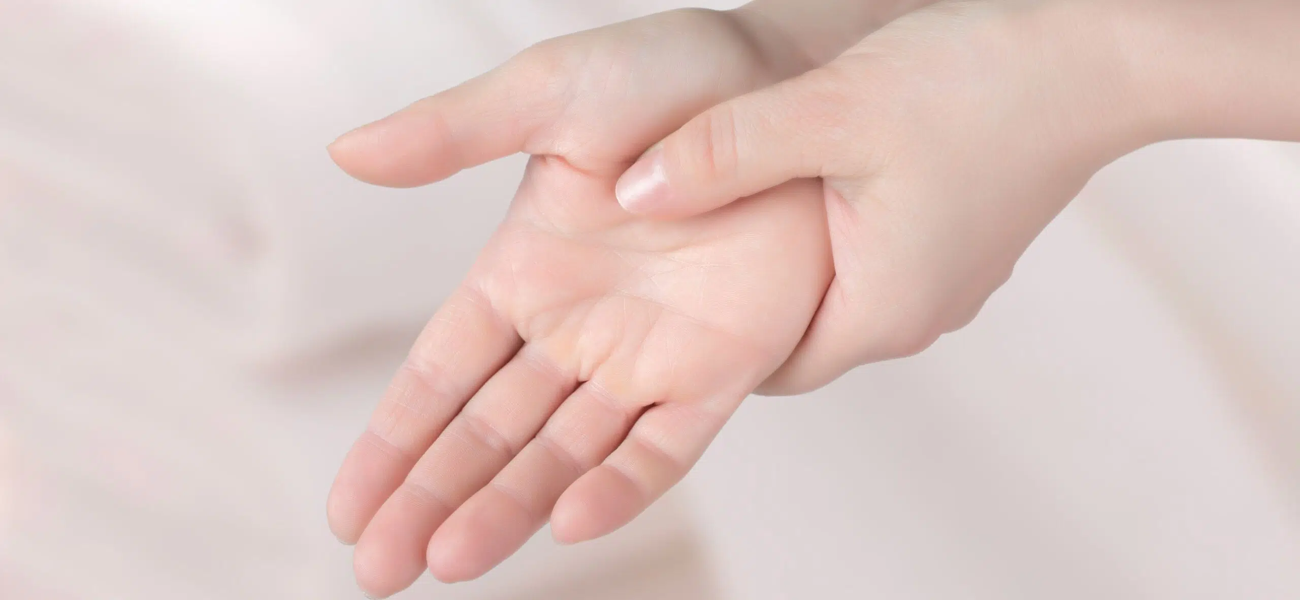 Main d'une femme pressant la paume de l'autre avec l'indexe | Leman hand Clinic Genève