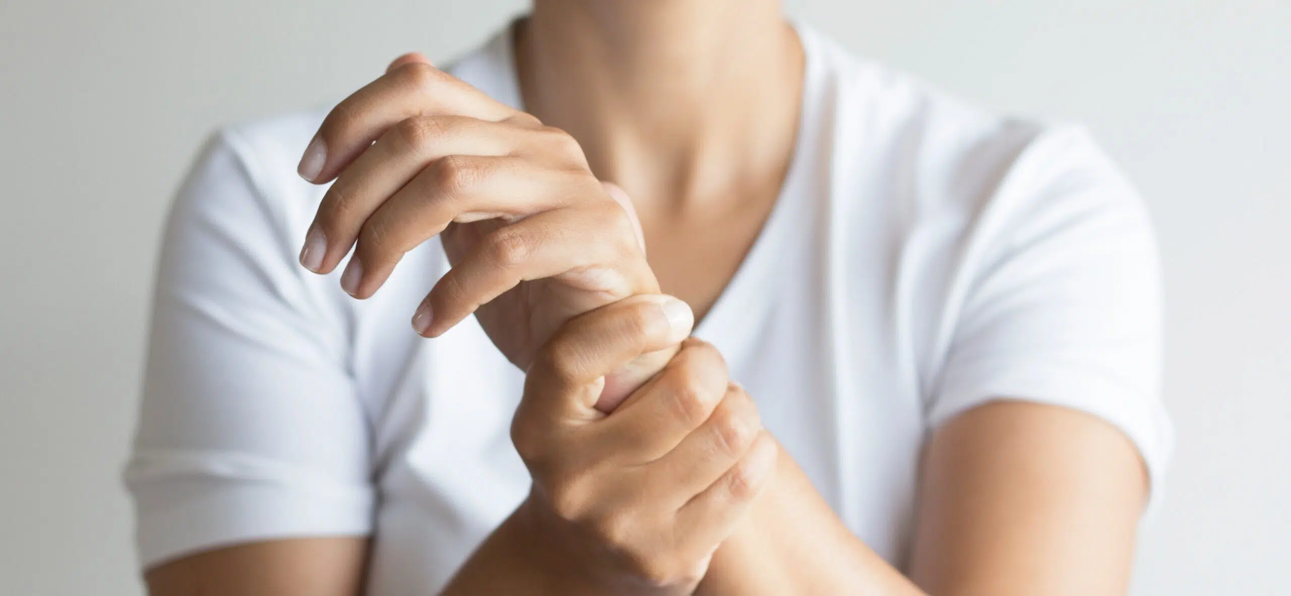 Homme tenant le poignet de sa main avec l'autre main | Leman hand Clinic Genève