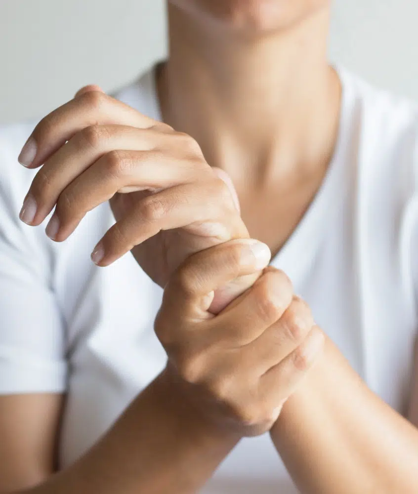 Homme tenant son poignet gauche avec sa main droite - fracture du poignet | Leman hand Clinic Genève