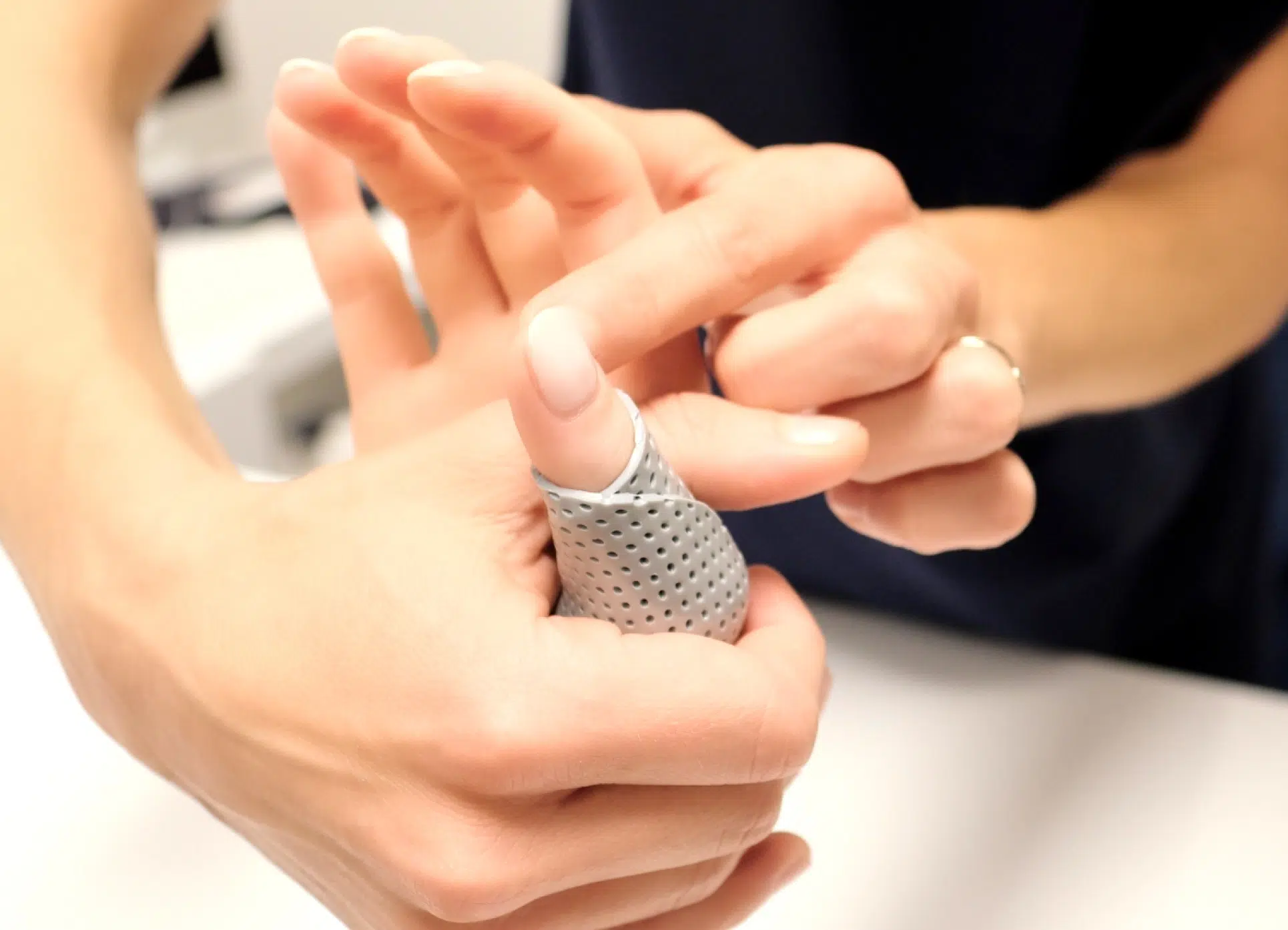 Photo rapprochée de deux mains une ajuste une attelle a l'autre - Attelle sur mesure | Leman hand Clinic Genève