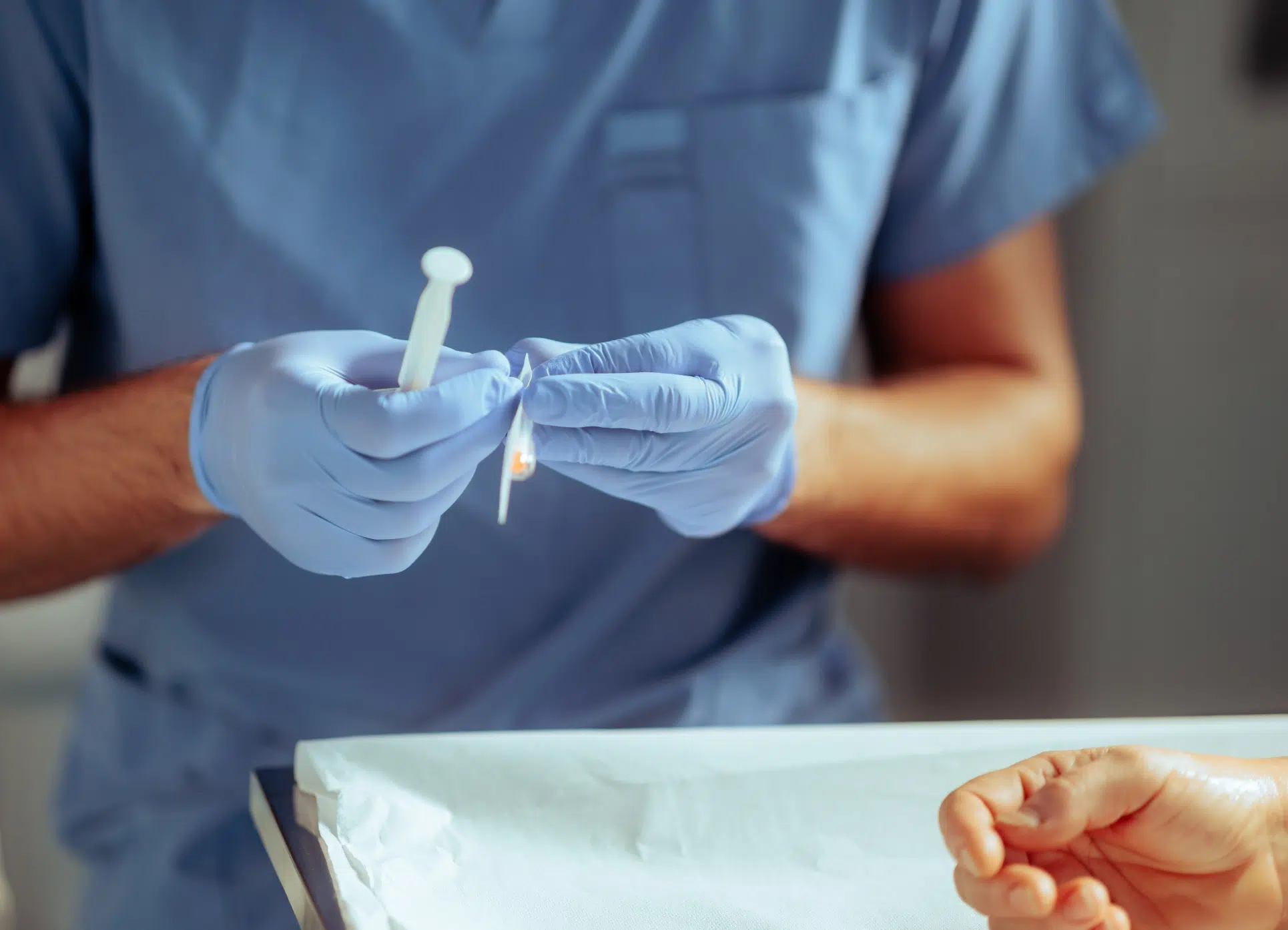 Inférmier manipulant une seringue et une aiguille - infiltration | Leman hand Clinic Genève