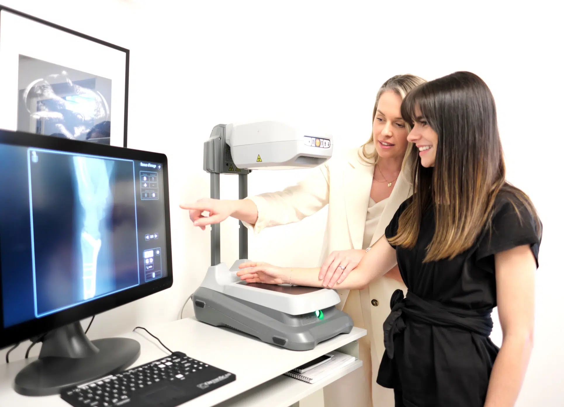 Femme posant sa main sur une machine à rayons X - plateau technique | Leman hand Clinic Genève