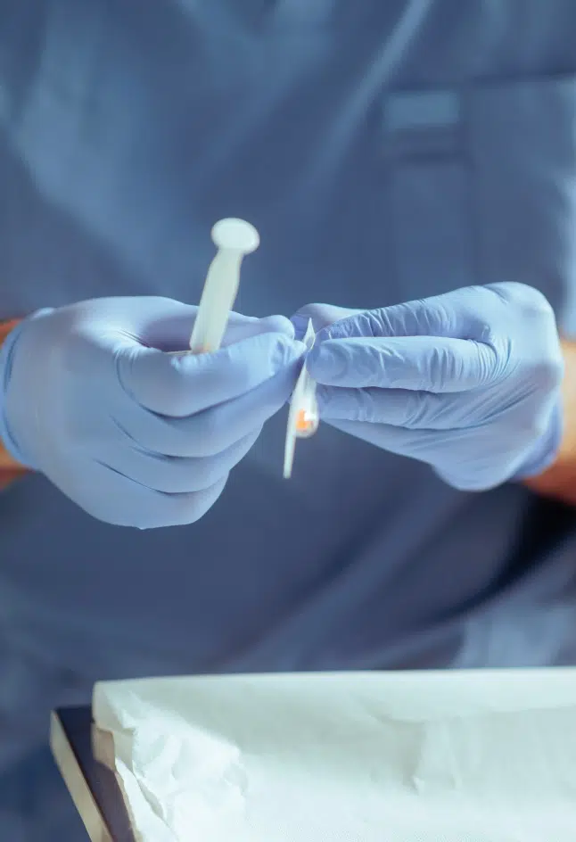 Deux mains manipulant une seringue - Infiltration | Leman hand Clinic Genève