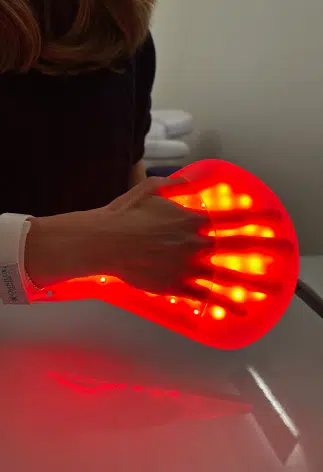 appareil lumineux qui enveloppe les doigts de la main - Luminothérapie | Leman hand Clinic Genève