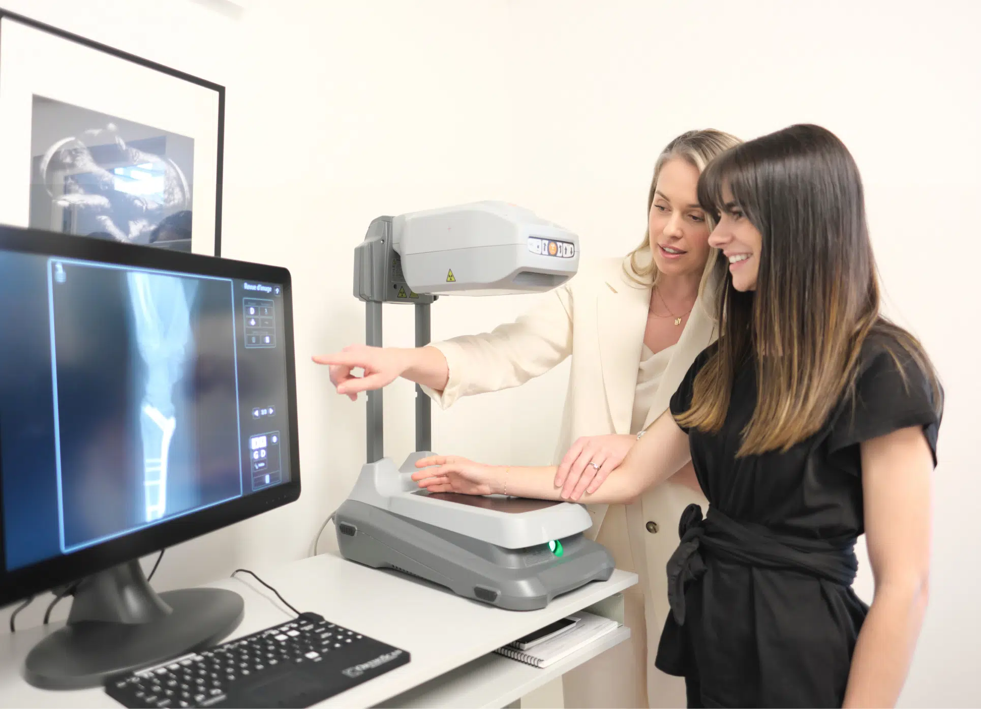 Femme posant sa main sur une machine à rayons X assisté par une professionnelle - plateau technique | Leman hand Clinic Genève